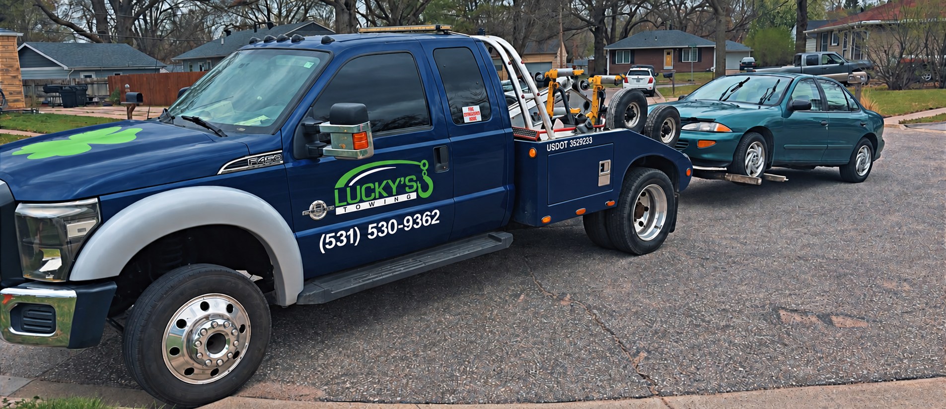 Lucky's Towing F-450 wrecker with a car on the wheel lift